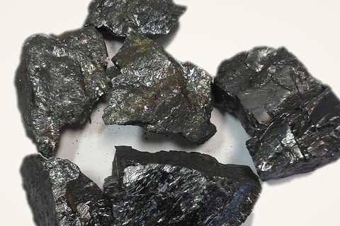 Lumps of anthracite coal on a pale backdrop